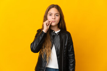 Child over isolated yellow background showing a sign of silence gesture