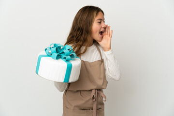 Little girl holding a big cake over isolated white background shouting with mouth wide open to the side