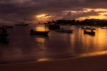 Purple sunset on a river beach full of fishing boats in Itacaré