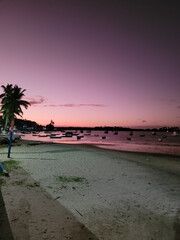 Purple sunset on a river beach full of fishing boats in Itacaré