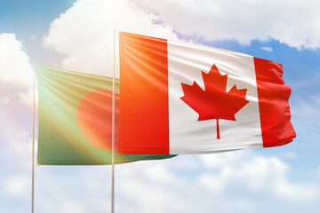 Sunny blue sky and flags of canada and bangladesh