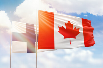 Sunny blue sky and flags of canada and finland