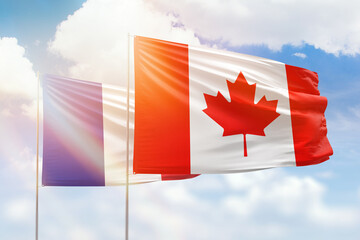 Sunny blue sky and flags of canada and france