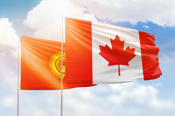 Sunny blue sky and flags of canada and kyrgyzstan