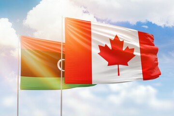 Sunny blue sky and flags of canada and libya