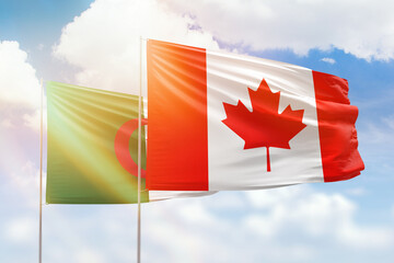 Sunny blue sky and flags of canada and algeria