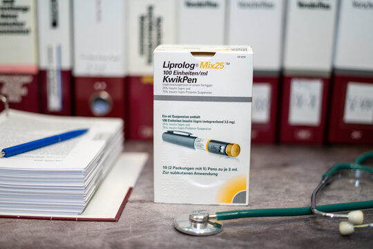 Drug Liprolog   containing insulin lispro for Diabetes Mellitus, on a table and in the background different medical books.
