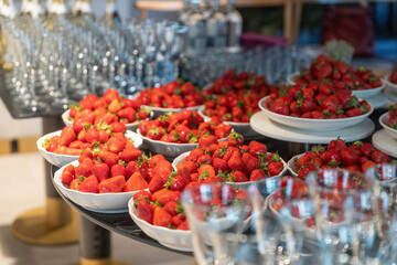 Banquet table. Strawberries in bowls and glasses for wine and champagne are on the table.