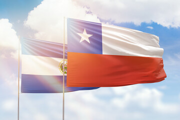 Sunny blue sky and flags of chile and el salvador