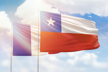 Sunny blue sky and flags of chile and france