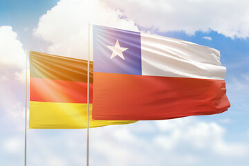 Sunny blue sky and flags of chile and germany
