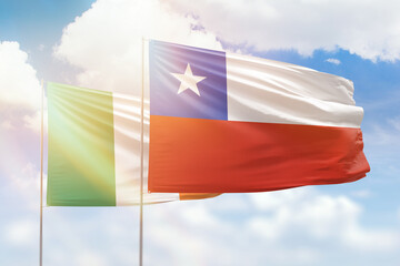 Sunny blue sky and flags of chile and ireland