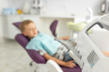 Blur picture. Cute small boy is visiting dentals doctor. The kid is sitting in medical chair