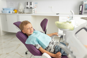 Dentist examining little boy's teeth in modern clinic