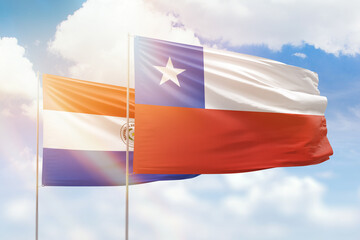 Sunny blue sky and flags of chile and paraguay