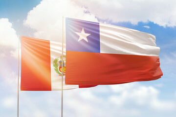 Sunny blue sky and flags of chile and peru