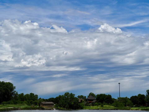 Developing thunderstorm with altocumulus clouds in the foreground. Summer thunderstorm over a Wichita lake. 