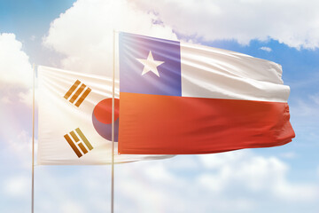 Sunny blue sky and flags of chile and south korea