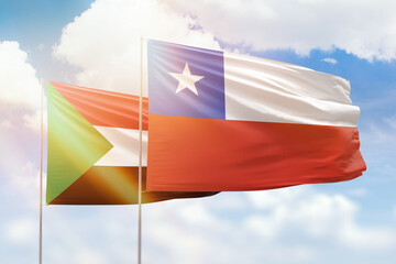 Sunny blue sky and flags of chile and sudan