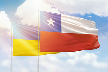 Sunny blue sky and flags of chile and ukraine