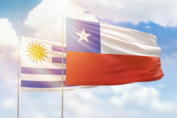 Sunny blue sky and flags of chile and uruguay