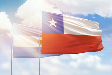 Sunny blue sky and flags of chile and argentina