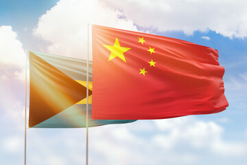 Sunny blue sky and flags of china and bahamas