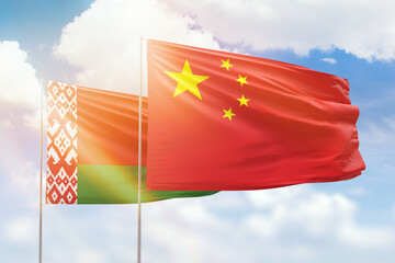 Sunny blue sky and flags of china and belarus