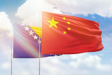 Sunny blue sky and flags of china and bosnia