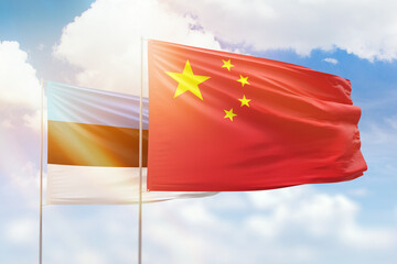 Sunny blue sky and flags of china and estonia