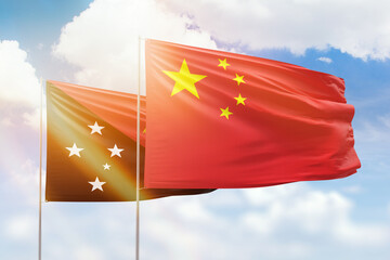 Sunny blue sky and flags of china and papua new guinea