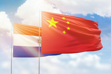 Sunny blue sky and flags of china and paraguay