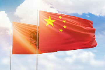 Sunny blue sky and flags of china and albania