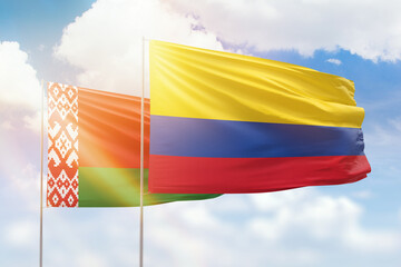 Sunny blue sky and flags of colombia and belarus