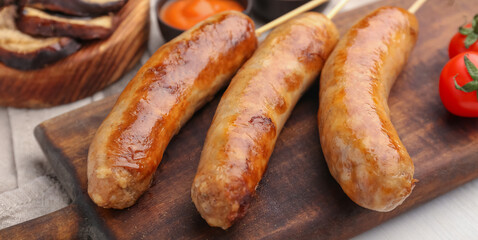 Tasty grilled sausages wooden board, closeup