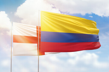Sunny blue sky and flags of colombia and england - obrazy, fototapety, plakaty