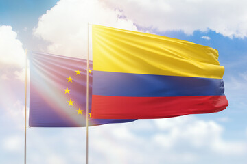 Sunny blue sky and flags of colombia and european union