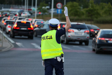 policjantka kieruje ruchem podczas Wieczorne korki samochodowe podczas szczytu komunikacyjnego  - obrazy, fototapety, plakaty