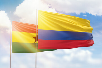 Sunny blue sky and flags of colombia and ghana