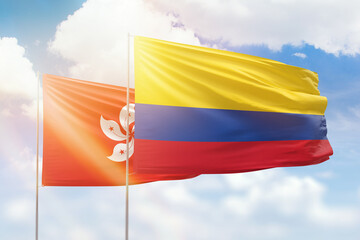 Sunny blue sky and flags of colombia and hong kong