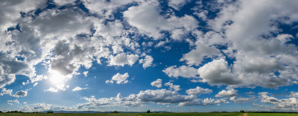 Panoramaansicht von Schönwetterwolken mit Horizont am unteren Bildrand und blauem Himmelim...