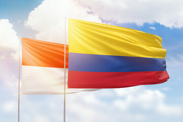 Sunny blue sky and flags of colombia and indonesia