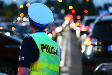 policjantka kieruje ruchem podczas Wieczorne korki samochodowe podczas szczytu komunikacyjnego  - obrazy, fototapety, plakaty
