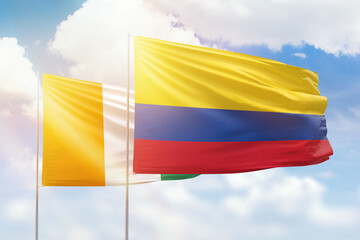 Sunny blue sky and flags of colombia and ivory coast