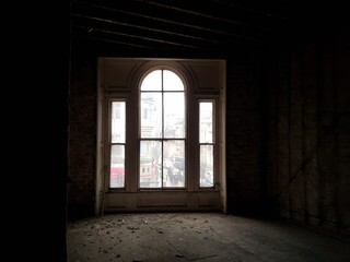 Fototapeta na wymiar A large window in an old, abandoned and dark house.