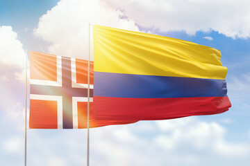 Sunny blue sky and flags of colombia and norway