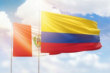 Sunny blue sky and flags of colombia and peru