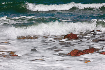 Sea waves with foam beating the rocks 