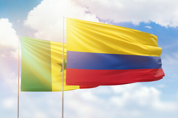 Sunny blue sky and flags of colombia and senegal