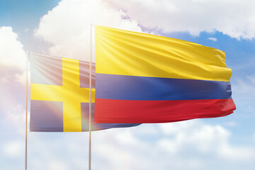 Sunny blue sky and flags of colombia and sweden